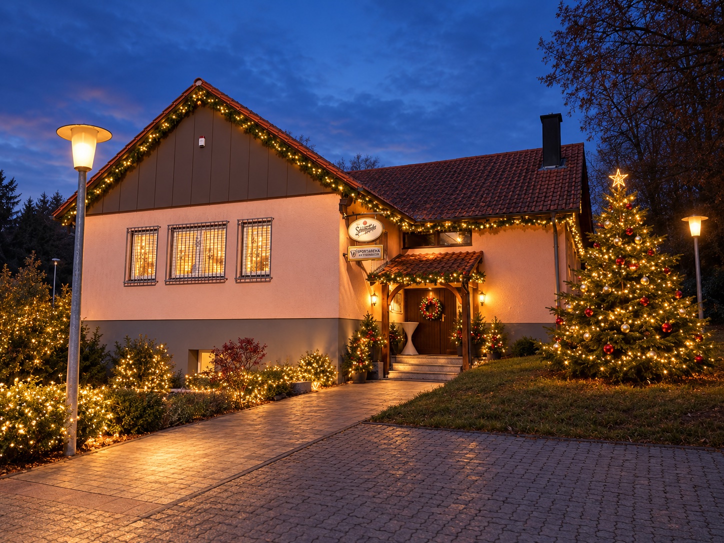 Weihnachtlich gestaltetes Sportheim des SV Steinbach mit geschmücktem Weihnachtsbaum und warmen Lichterketten in Abendstimmung.