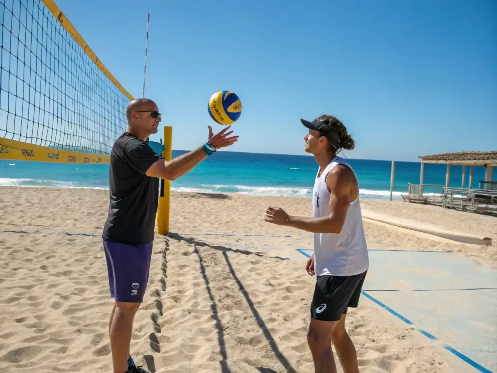 A close-up shot of a beach volleyball training session, with a coach providing personalized instruction to a player. The focus is on the technical aspects of the sport, with the coach demonstrating proper techniques and offering constructive feedback.